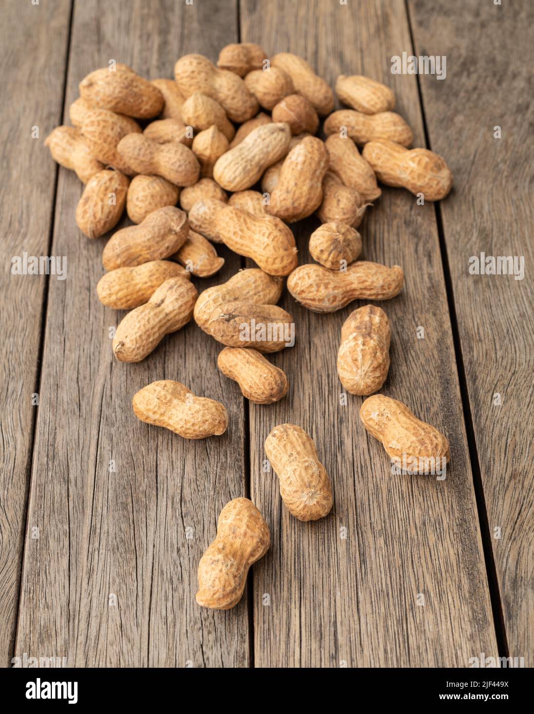 Ein Haufen geschälter Erdnüsse über dem Holztisch. Stockfoto