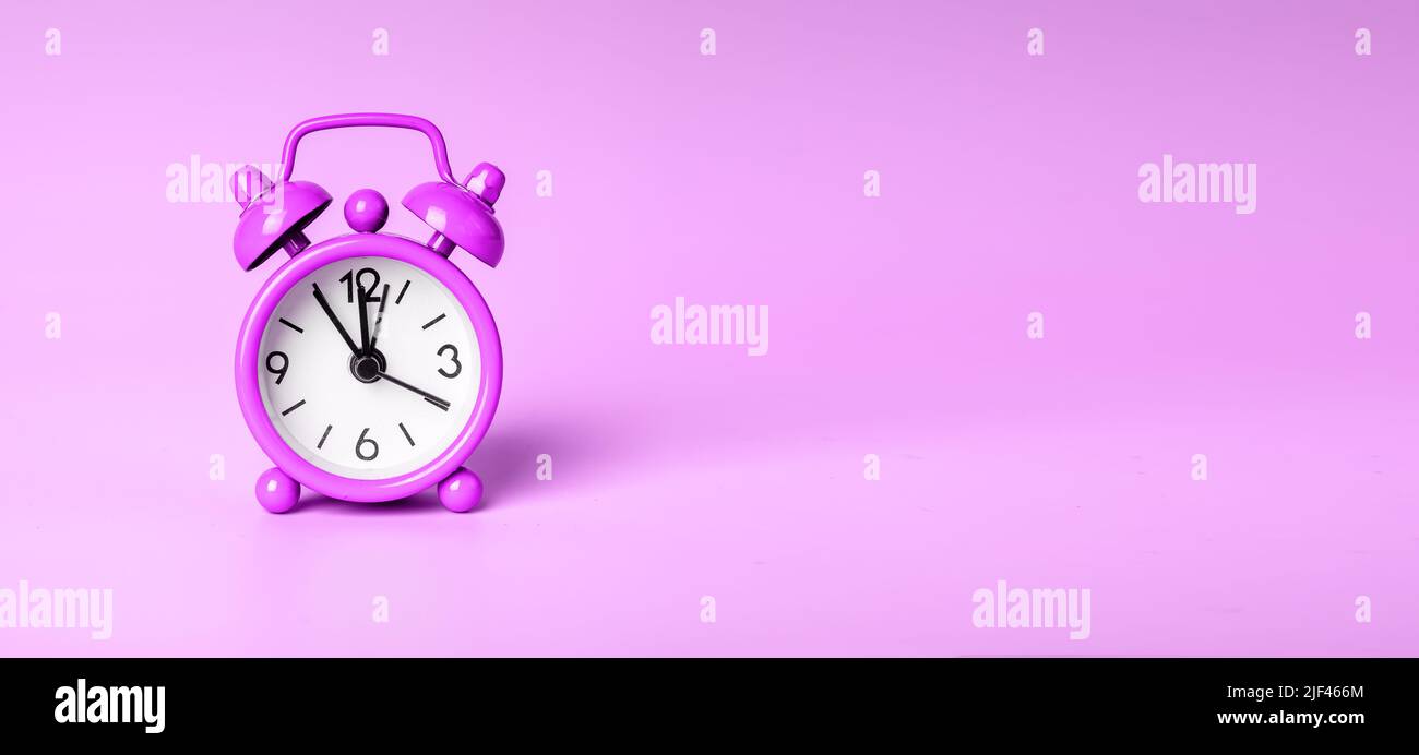 Retro-Wecker auf violettem Banner mit Platz für Text. Hochwertige Fotos Stockfoto
