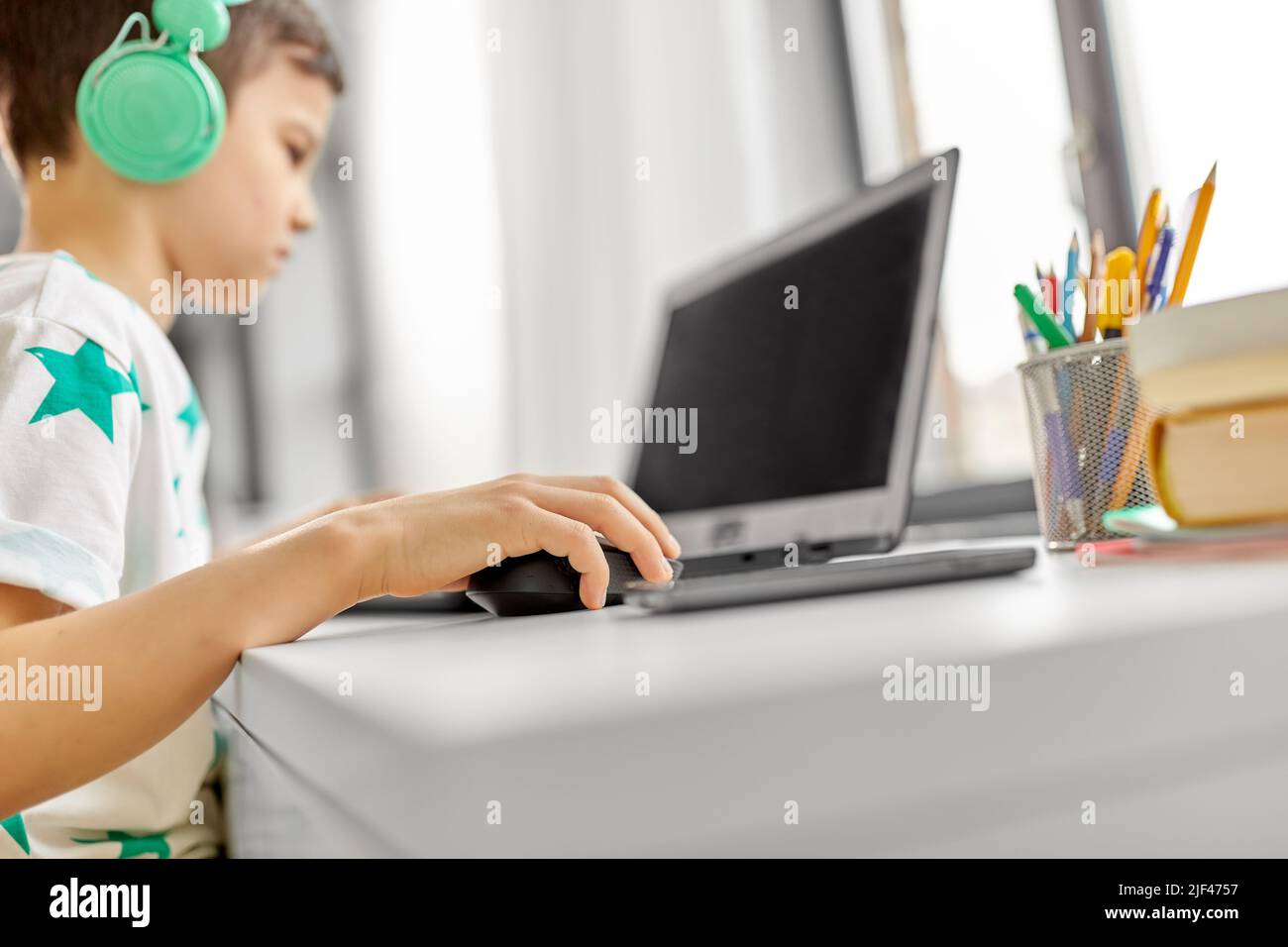 Junge in Kopfhörer spielen video game auf Laptop Stockfoto