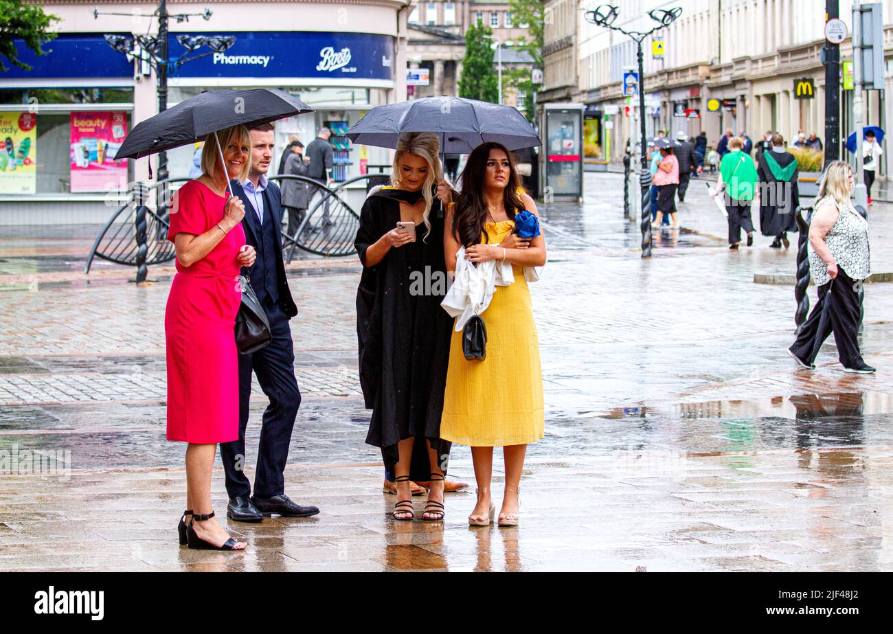 Dundee, Tayside, Schottland, Großbritannien. 29.. Juni 2022. Wetter in Großbritannien. Die Kombination aus unerwarteten, starken Regengüssen und Feuchtigkeit führte in bestimmten Gebieten Nordostschottlands zu Temperaturen von über 17 Grad Studenten der Dundee University und ihre Familien werden am Graduation Day von schweren, verstreuten Schauern auf dem City Square und der Caird Hall im Stadtzentrum von Dundee aus der Wache genommen. Kredit: Dundee Photographics/Alamy Live Nachrichten Stockfoto