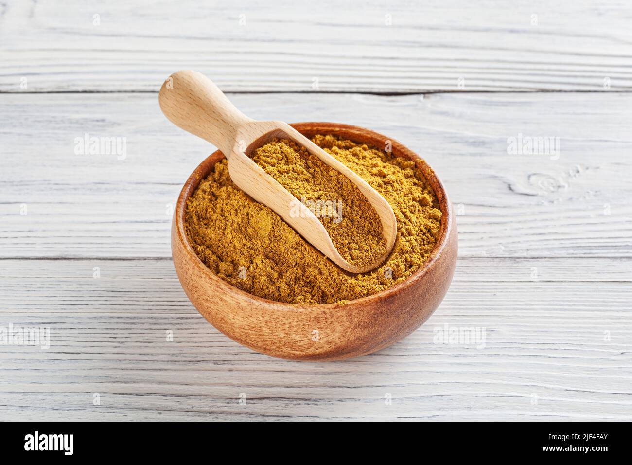 In einer Holzschüssel auf weißem Holzhintergrund gepudert Stockfoto