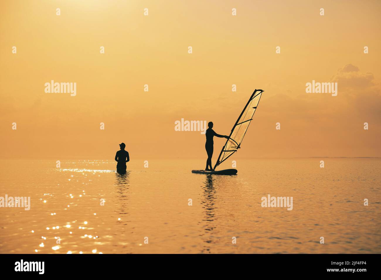 Sonnenuntergang auf dem Meer mit Silhouette von Girl mit einem Paddel auf einem SUP-Board Stockfoto
