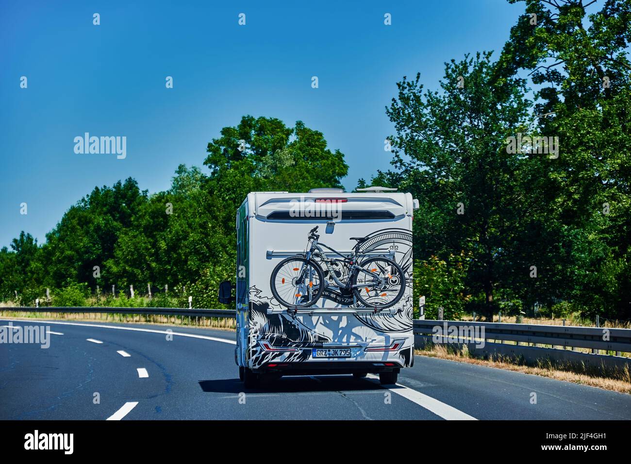 Brandenburg, Deutschland - 21. Juni 2022: Camper mit Fahrradträger am Heck und Fahrrad auf Landstraße. Stockfoto