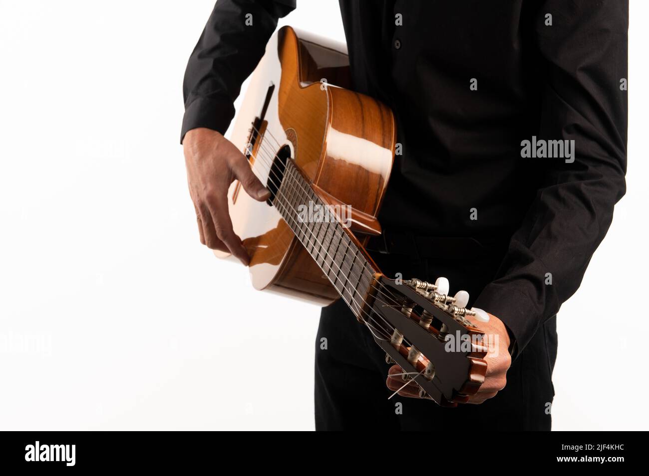 Isolierte klassische Gitarre und die Hände des Gitarristen spielen auf einem weißen Hintergrund mit Kopierraum Stockfoto