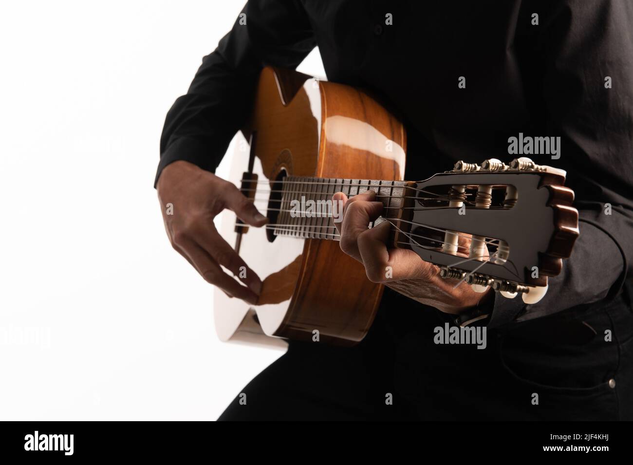 Isolierte klassische Gitarre und die Hände des Gitarristen aus nächster Nähe auf weißem Hintergrund. Stockfoto