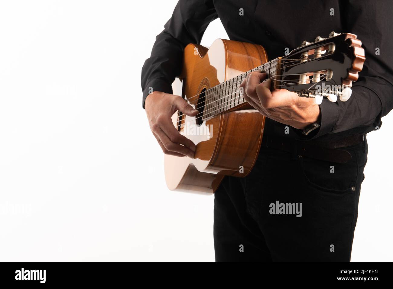 Isolierte klassische Gitarre und die Hände des Gitarristen aus nächster Nähe auf weißem Hintergrund. Stockfoto