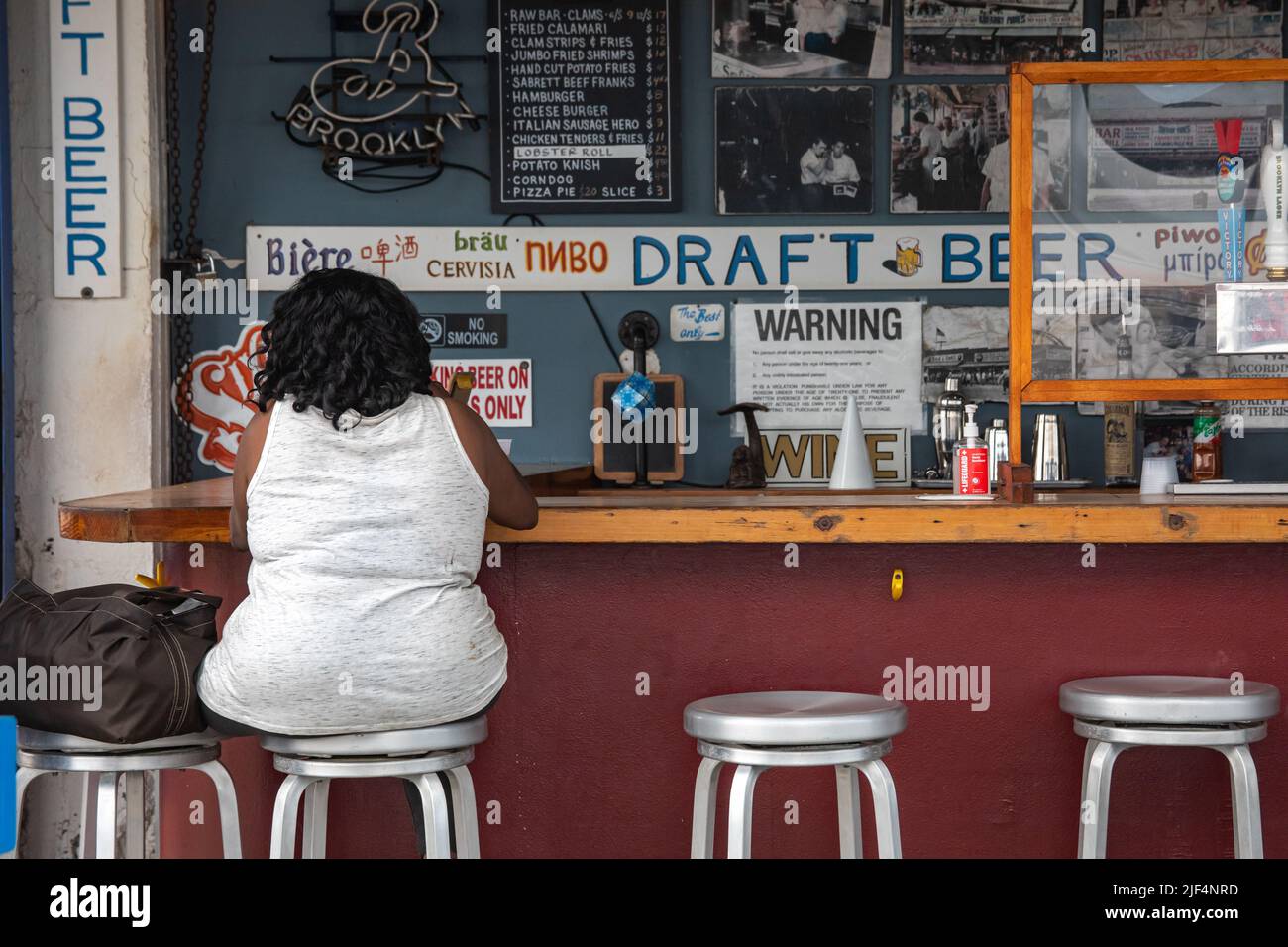 Kundin, die am Barschalter im Vergnügungspark-Restaurant der Paul'd-Tochter im Stadtteil Coney Island in Brooklyn, New York City, USA, sitzt Stockfoto