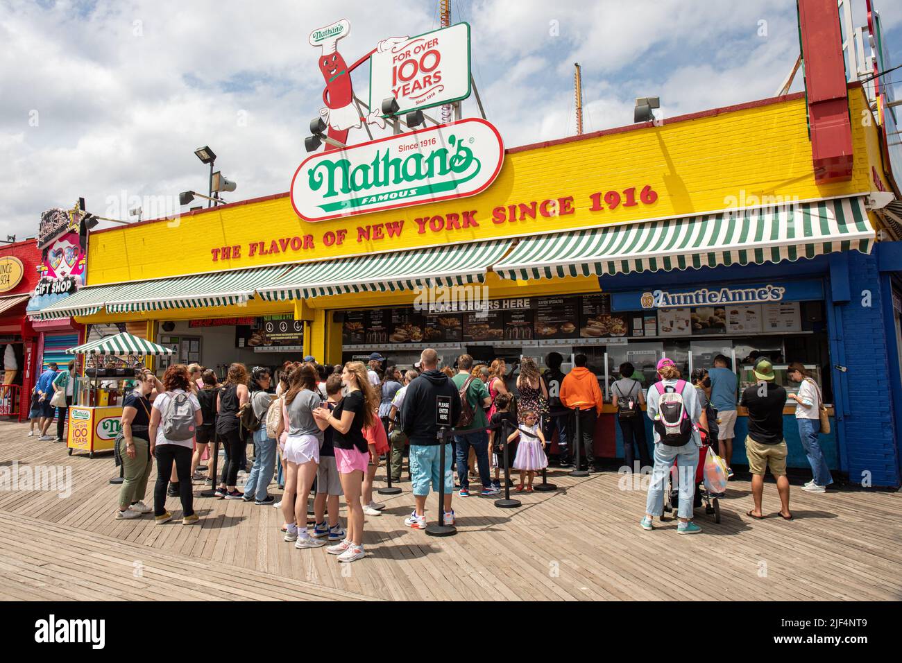 Menschen stehen vor Nathan's berühmtem Fast-Food-Restaurant im Coney Island Vergnügungspark in Brooklyn, New York City, USA Stockfoto