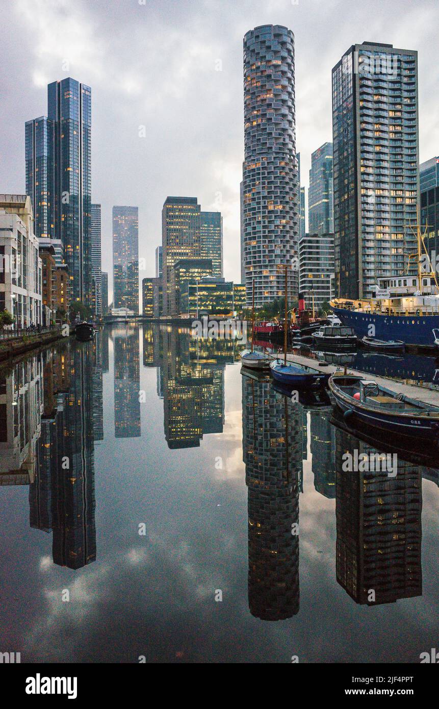 Die Wolkenkratzer von Canary Wharf auf der Isle of Dogs spiegeln sich in der Abenddämmerung auf dem Wasser des South Dock, East London 2021. Stockfoto