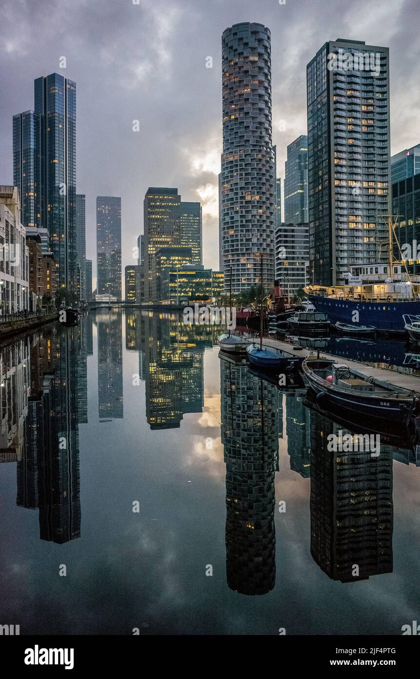 Die Wolkenkratzer von Canary Wharf auf der Isle of Dogs spiegeln sich in der Abenddämmerung auf dem Wasser des South Dock, East London 2021. Stockfoto