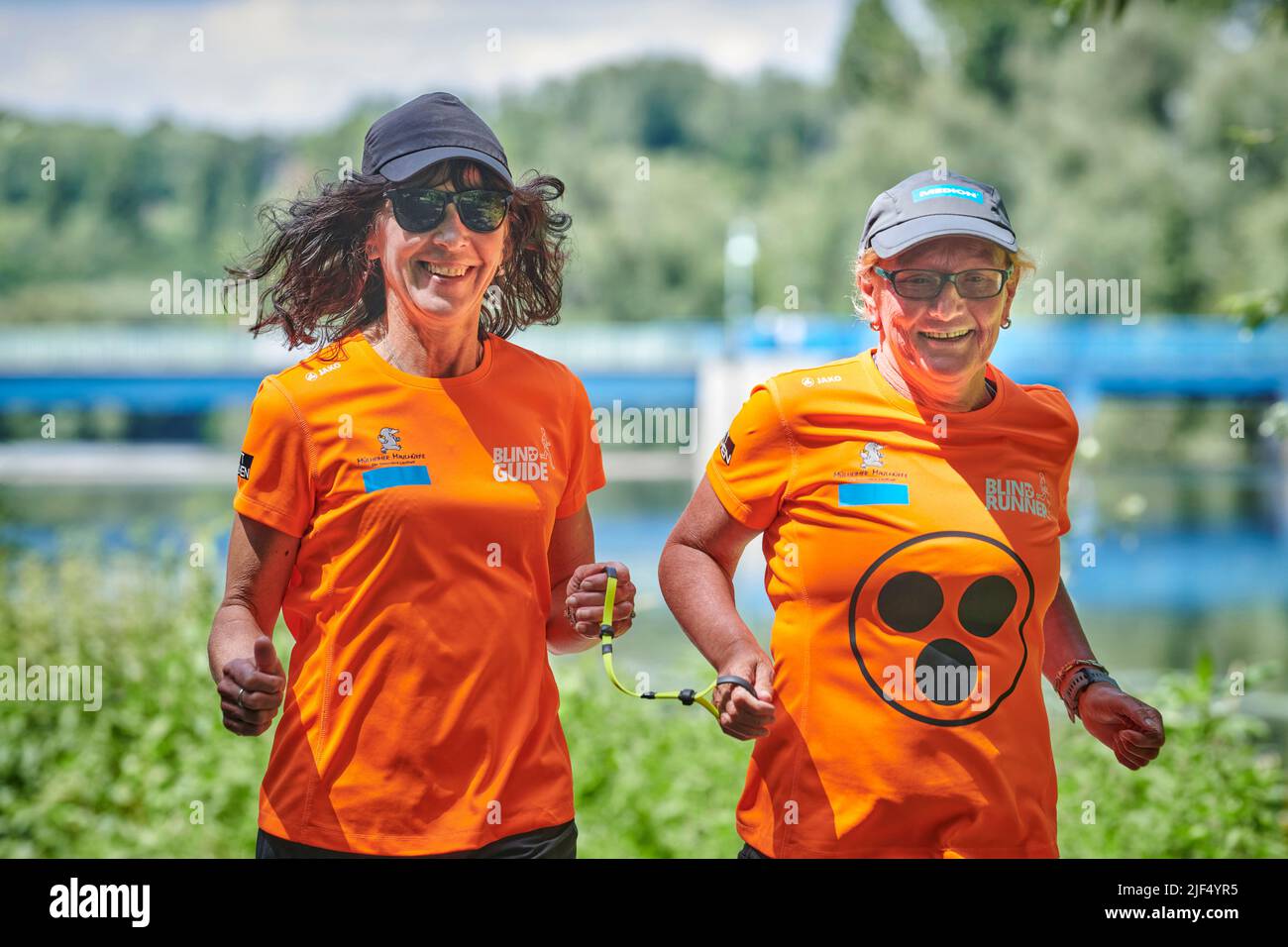 Sehbewehrte Joggerin mit ihrer weiblichen Laufguide. In einigen werden Laufguides for bilinde and sehbeeintraechtigte Laeuferinnen ausgestellt Stockfoto