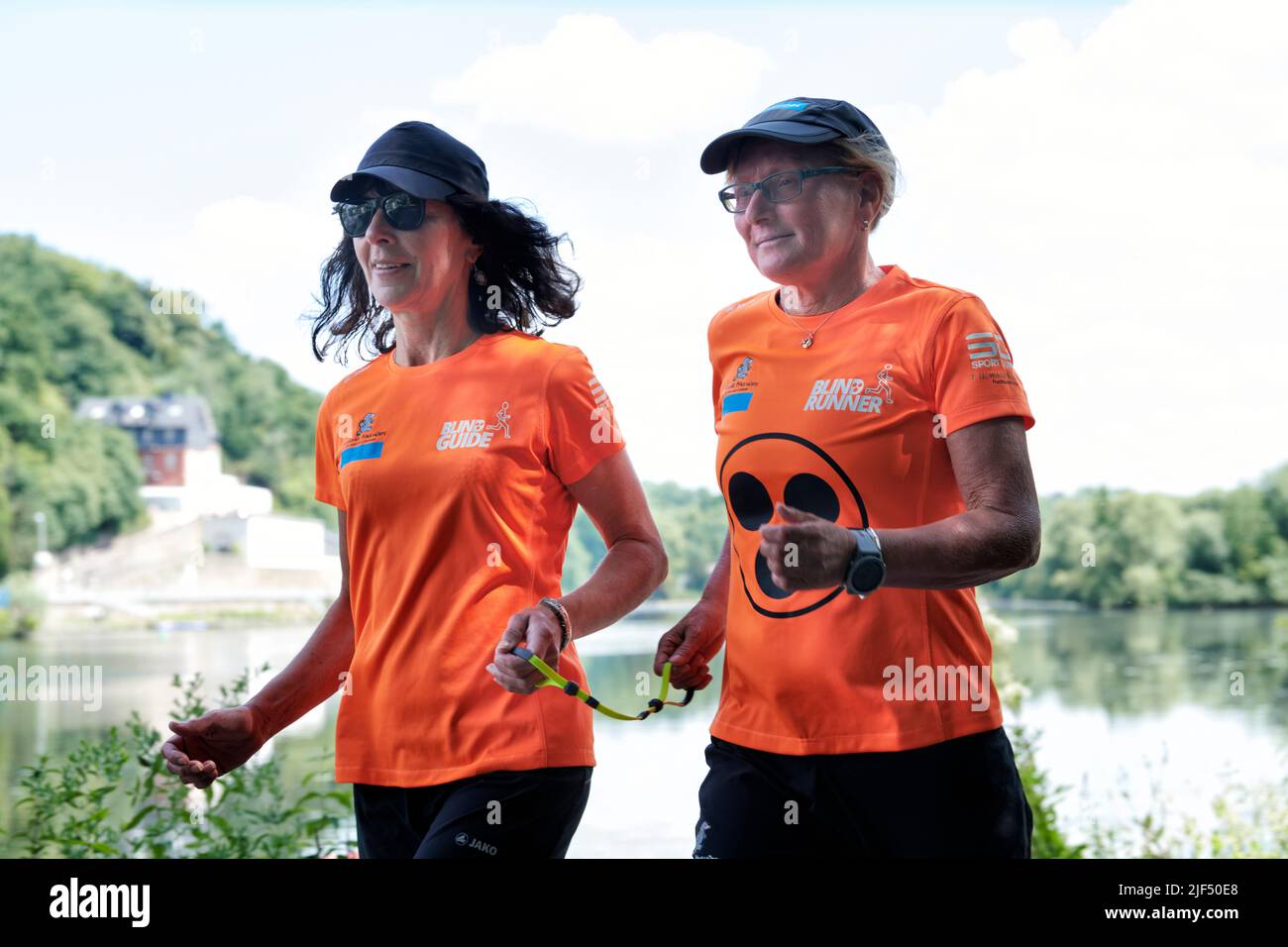 Sehbewehrte Joggerin mit ihrer weiblichen Laufguide. In einigen werden Laufguides for bilinde and sehbeeintraechtigte Laeuferinnen ausgestellt Stockfoto