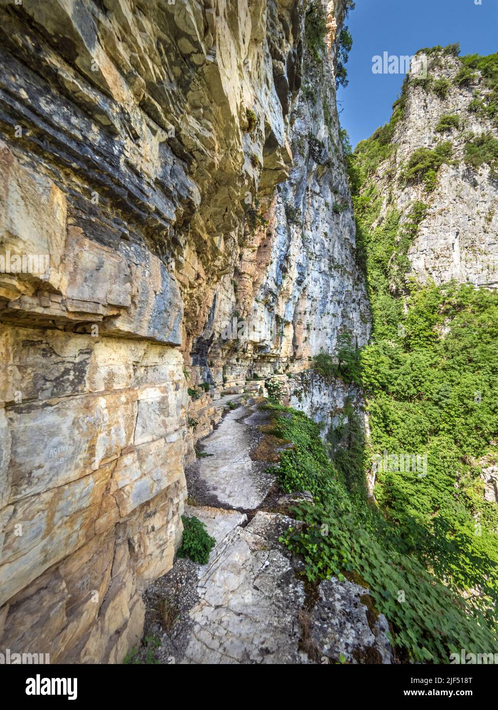Enger, prekärer Pfad, der in die schiere Felswand hinter dem Kloster Agia Paraskevi hoch über der Vikos-Schlucht in der Region Zagori in Griechenland eingehauen ist Stockfoto
