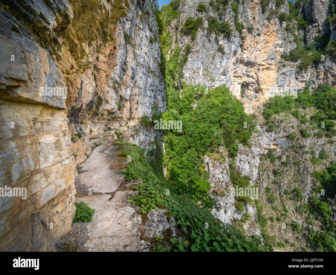 Enger, prekärer Pfad, der in die schiere Felswand hinter dem Kloster Agia Paraskevi hoch über der Vikos-Schlucht in der Region Zagori in Griechenland eingehauen ist Stockfoto