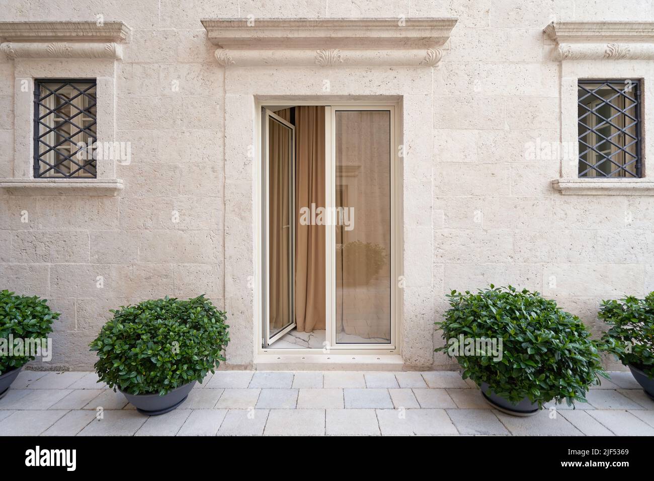 Elegante, beigefarbene Glastür an der Fassade eines Luxusgebäudes. Stockfoto
