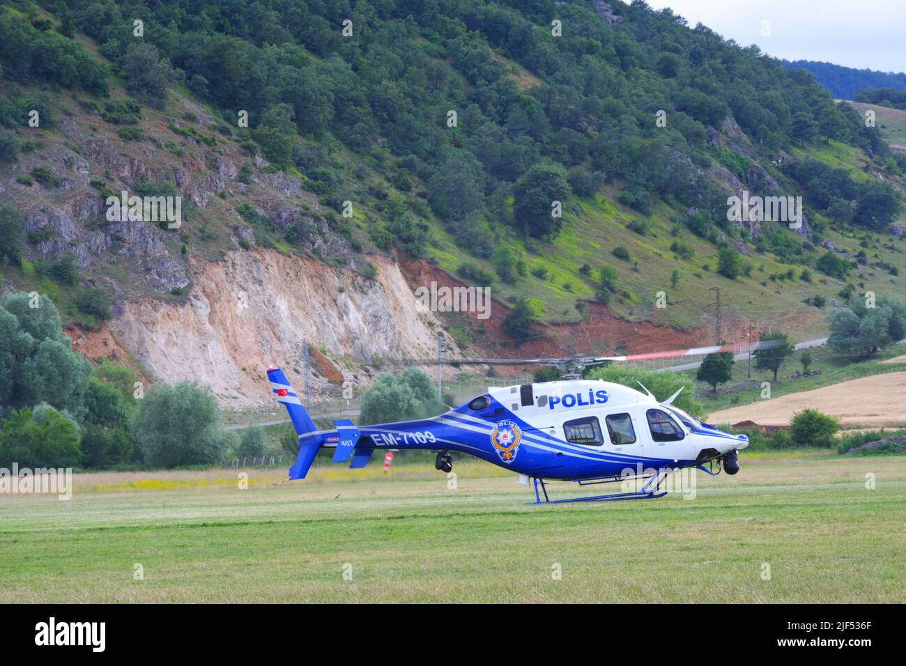 Der Hubschrauber der türkischen Polizei landet auf Gras, wobei sich die Rotoren der funktionierenden Motoren drehen Stockfoto