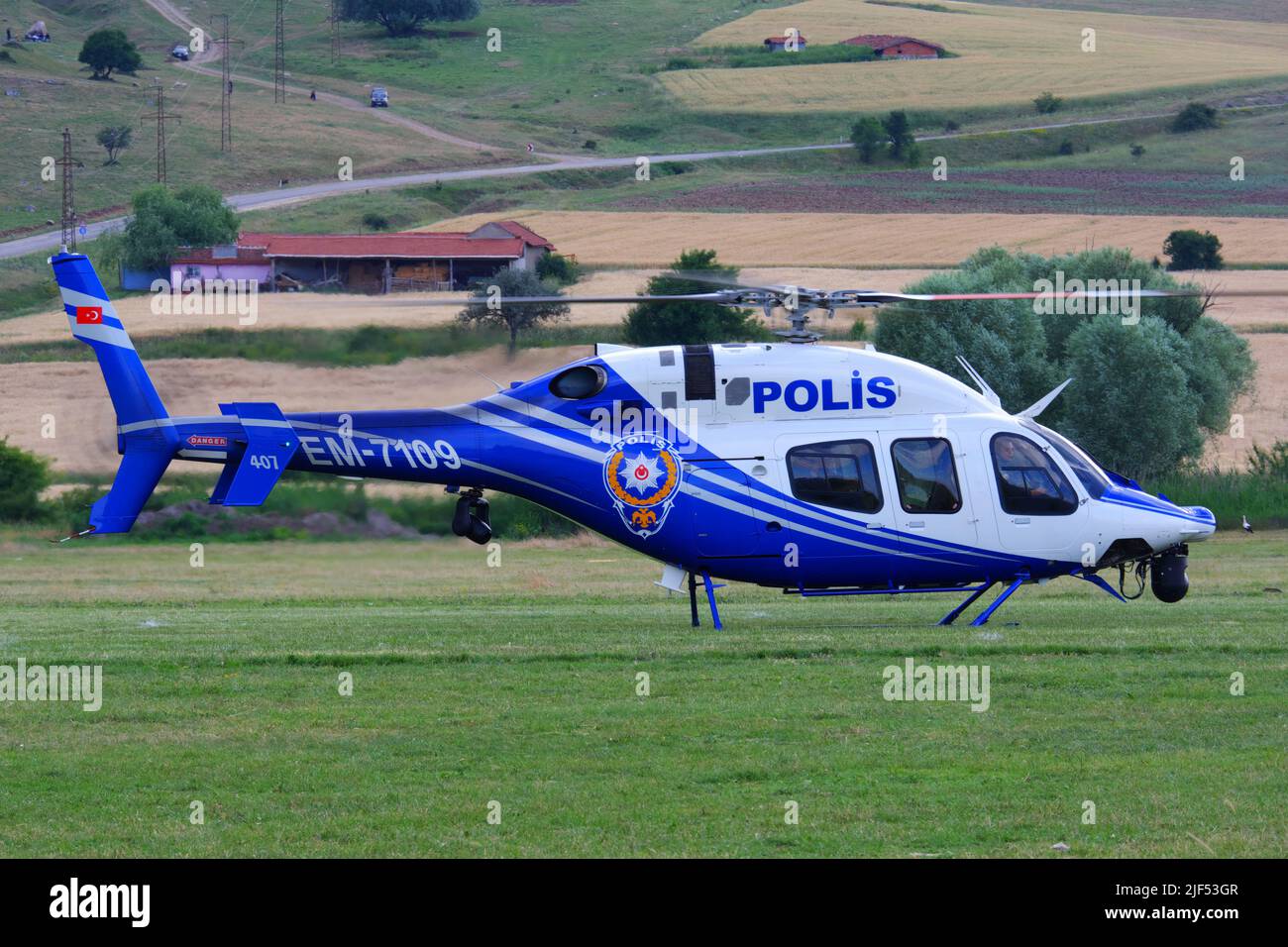 Der Hubschrauber der türkischen Polizei landet auf Gras, wobei sich die Rotoren der funktionierenden Motoren drehen Stockfoto