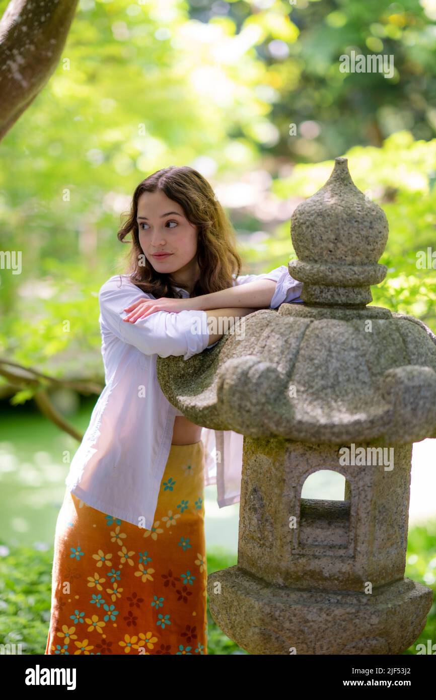 Porträt eines Porträts einer jungen Frau, die in einem japanischen Garten steht Stockfoto
