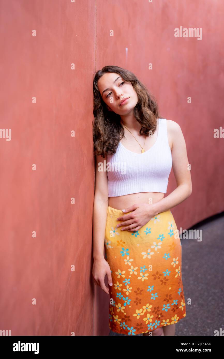 Porträt einer jungen Frau im Skyspace am späten Nachmittag | rote tonfarbene Wände Stockfoto