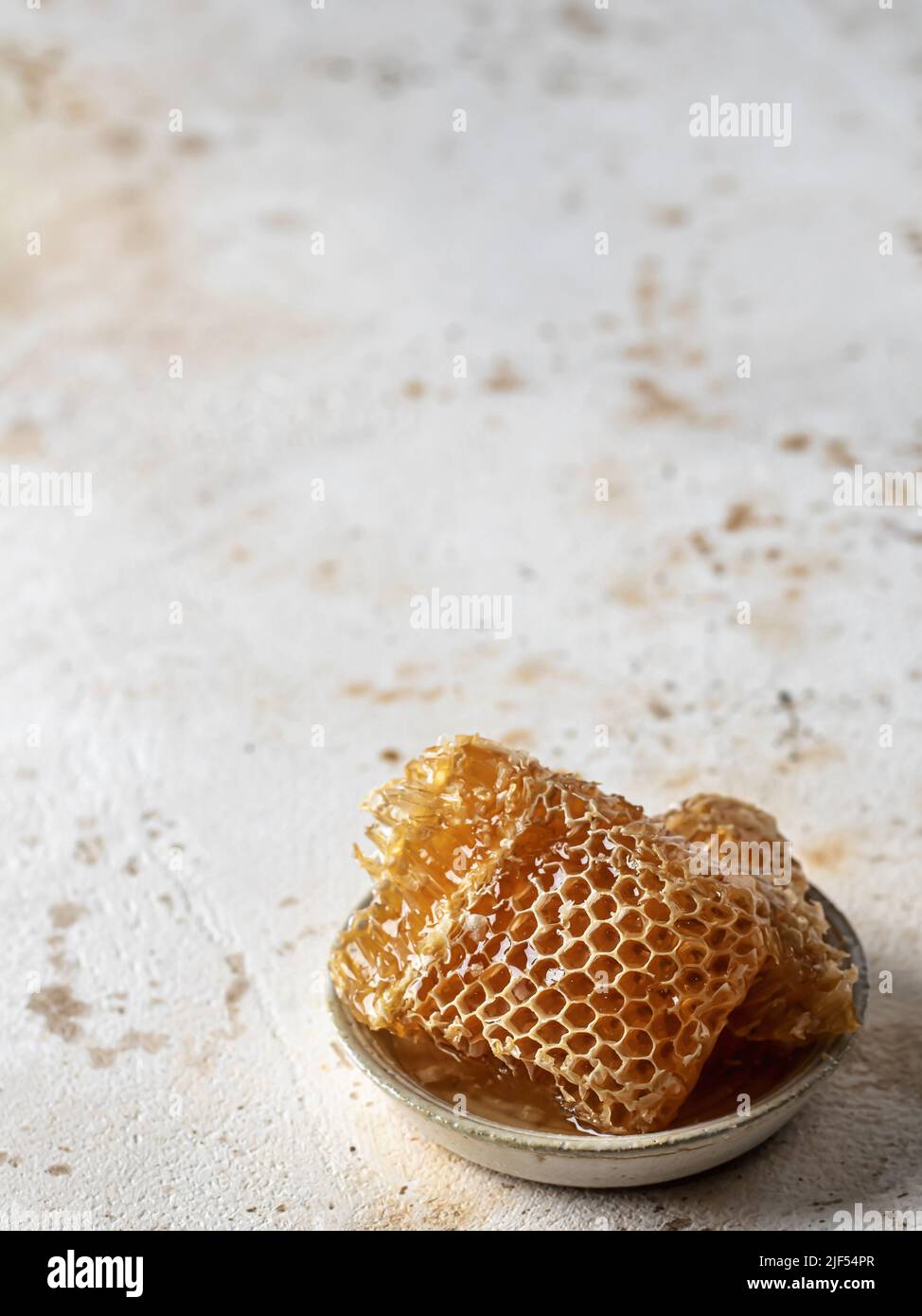 Honig in Honigwabe in einer Untertasse. Speicherplatz kopieren. Vertikale Ausrichtung Stockfoto