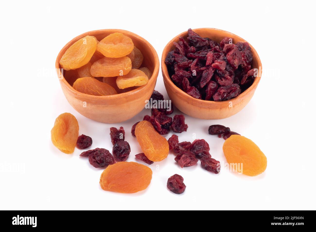 Getrocknete Aprikosen und Preiselbeeren isoliert auf hellem Hintergrund. Trockenobstkonzept. Nahaufnahme. Stockfoto