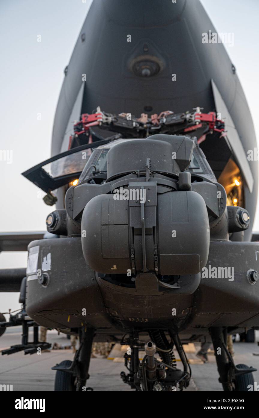 Ein Apache-Hubschrauber wartet auf die Beladung auf einen C-17 Globemaster III auf dem Ali Al Salem Air Base, Kuwait, 23. Juni 2022. Luftträger der 386. ELRS und Luftfahrtspezialisten der U.S. Army 11. Expeditionary Combat Aviation Brigade führten Hilfe an Stelle/Übertragung der Autorität von Apache-Hubschraubern durch, die dem U.S. Army 101. Aviation Bataillon zugewiesen wurden. (USA Luftwaffe Foto von Senior Airman Natalie Filzen) Stockfoto