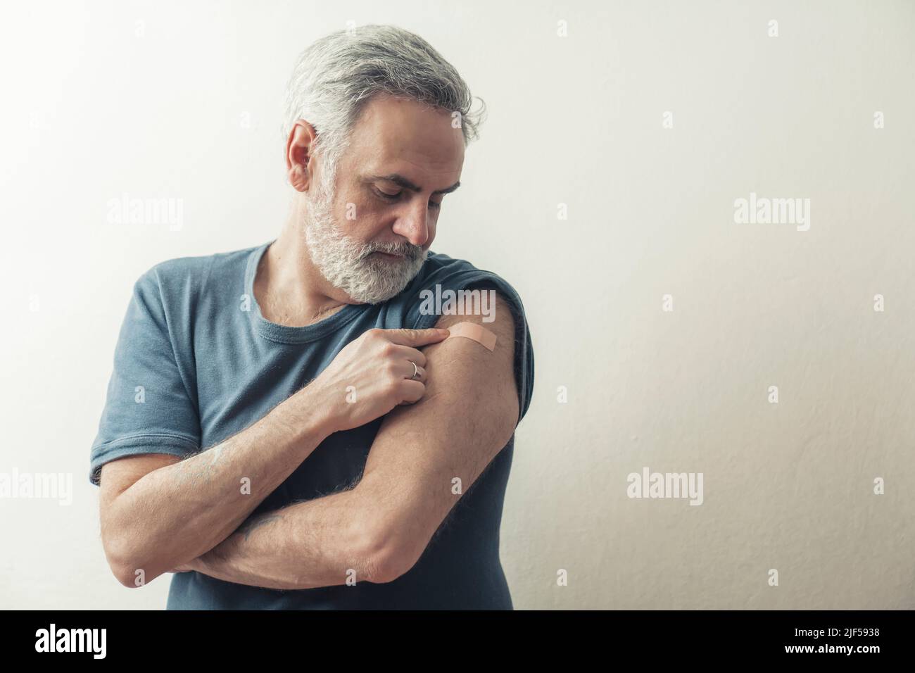 Mann mittleren Alters zeigt Patch auf seinem Arm Studio Schuss isoliert Kopie Raum drinnen . Hochwertige Fotos Stockfoto