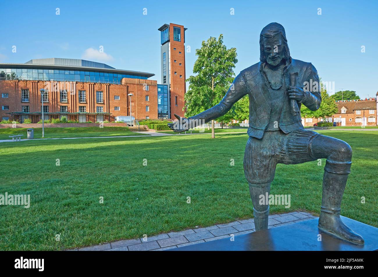Statue von William Shakespeare mit ausgestrecktem Arm in den Bancroft Gardens Stratford-upon-Avon, dahinter das Royal Shakespeare Theater Stockfoto