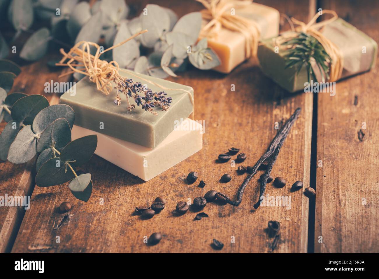 Natürliche Bio-Seifenstücke mit Vanille, Kaffeebohnen und Eukalyptus auf Holzhintergrund Stockfoto