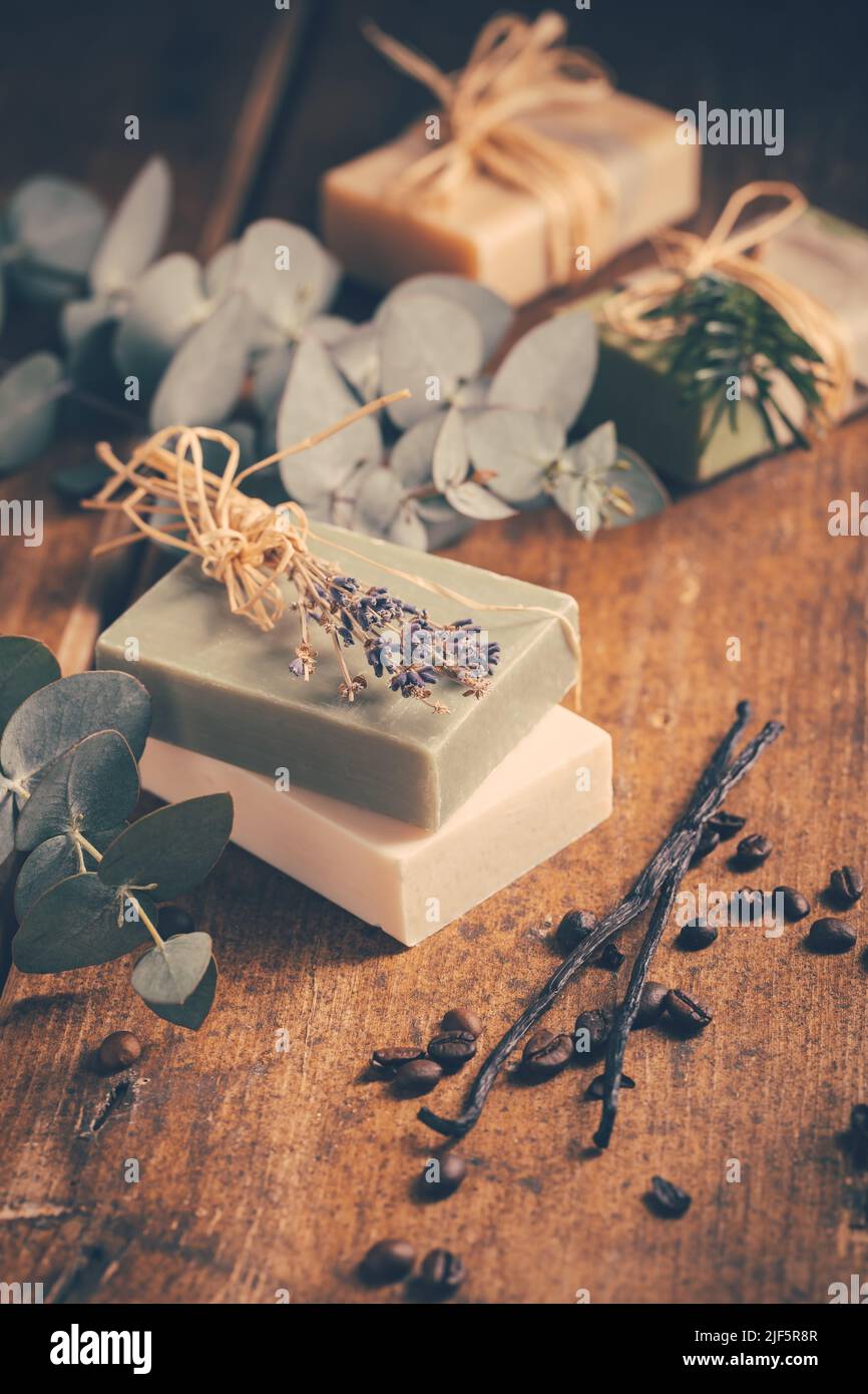 Natürliche Bio-Seifenstücke mit Vanille, Kaffeebohnen und Eukalyptus auf Holzhintergrund Stockfoto