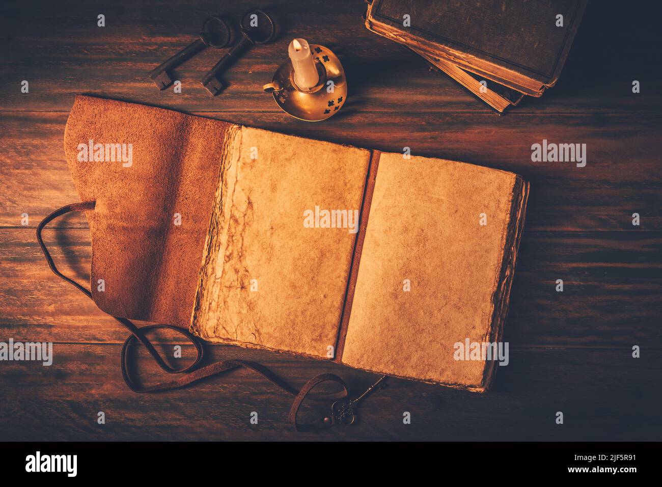Leeres antikes ledergebundenes Tagebuch, Buch oder Tagebuch mit alten Büchern und Kerze Stockfoto