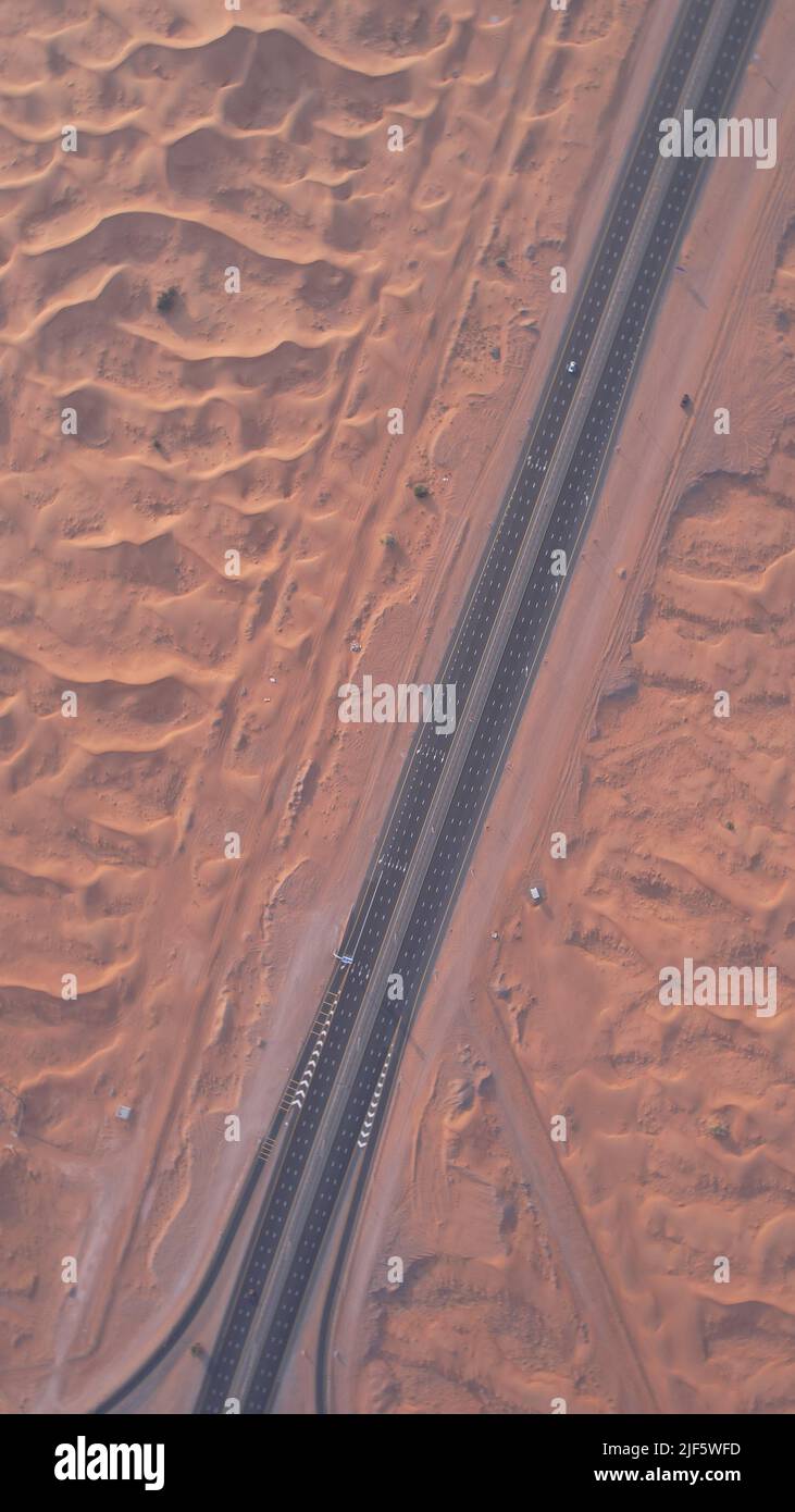 Aus der Vogelperspektive auf Sanddünen und eine Autobahn in einer Wüste von Sharjah, VAE, Naher Osten Stockfoto