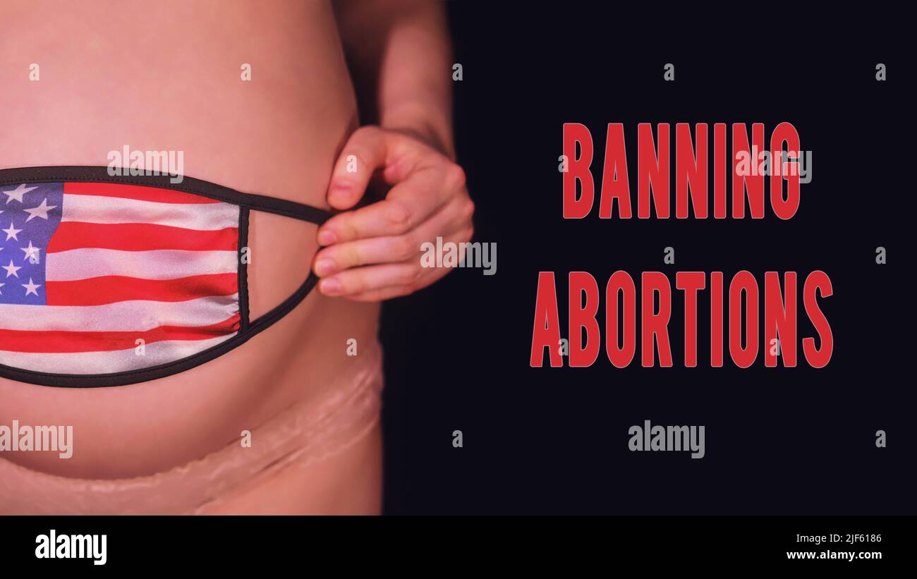 Inschrift Verbot Abtreibung und Schwangeren auf schwarzem Hintergrund mit medizinischer Maske und usa-Flagge. Das Konzept der Probleme mit dem Coronavirus während der PR Stockfoto