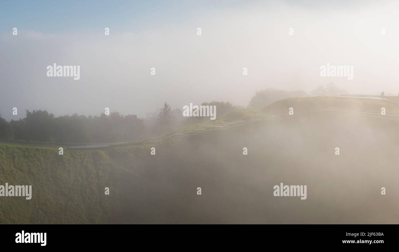 Dichter Nebel, der über dem Vulkankrater auf dem Gipfel des Mount Eden in Auckland driftet Stockfoto