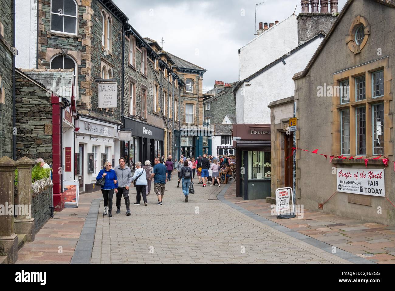 Besucher, die durch die Einkaufsstraßen der Lake District-Stadt Keswick in Cumbria schlendern Stockfoto