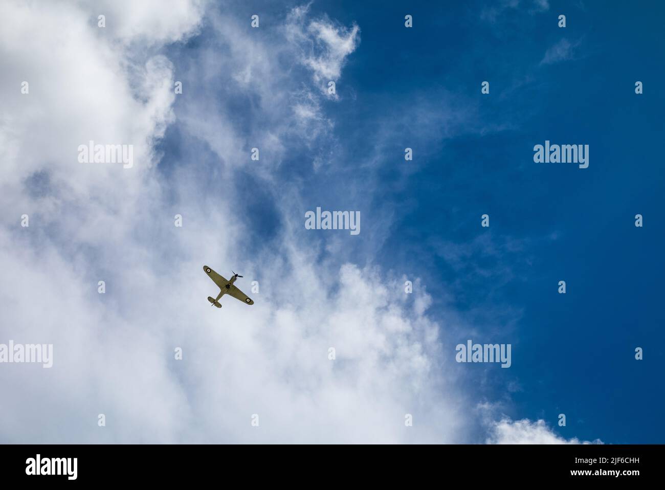 Ein alter Hawker-Ungehege aus der Zeit des Zweiten Weltkriegs, ein einsitziger Jagdflugzeug, der hoch oben am Himmel gegen Wolken über Billingshurst, West Sussex, Großbritannien, zu sehen ist. Stockfoto