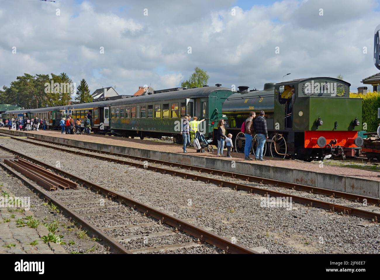 Menschen beobachten die konservierte britische Dampflok Hunslet Austerity WD 196 bei der Arbeit mit Personenzügen der Maldegem Heritage Railway, Flandern, Belgien Stockfoto