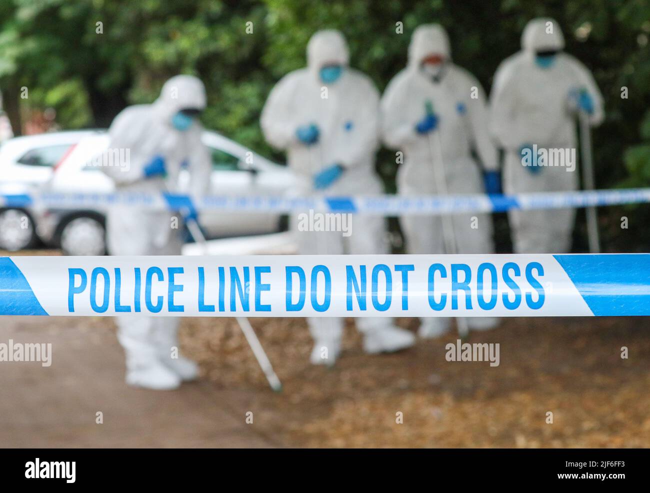 Polizeistreifen an einem Tatort im Vereinigten Königreich, als Szenen von Kriminalbeamten auftappen. Stockfoto