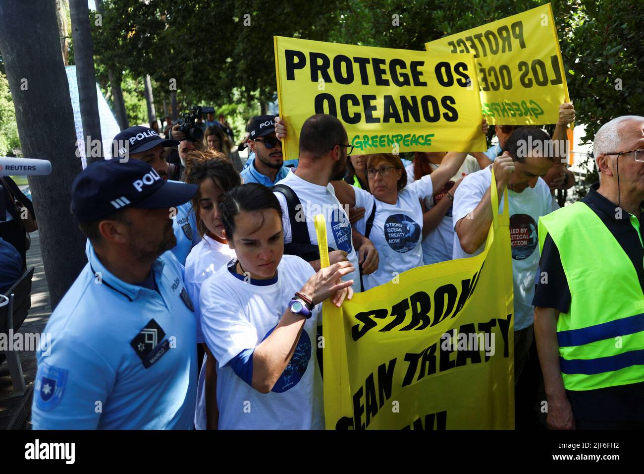 Greenpeace-Aktivisten werden von der Polizei gedrängt, während sie Transparente mit der Aufschrift: „Protect the Oceans“ während einer Demonstration vor der UN-Ozeankonferenz in Lissabon, Portugal, am 30. Juni 2022, hielten. REUTERS/Pedro Nunes Stockfoto