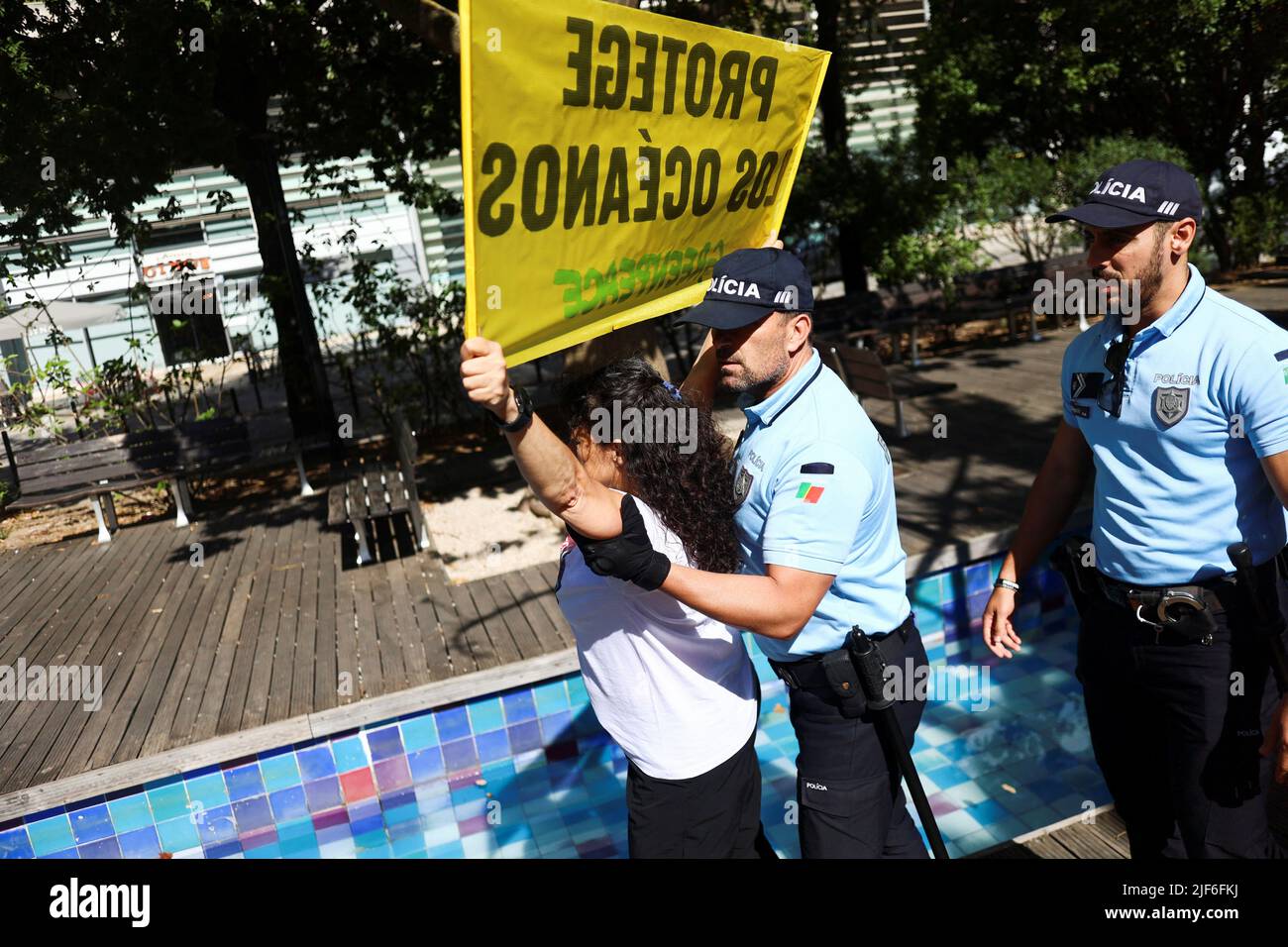 Greenpeace-Aktivisten werden von der Polizei gedrängt, während sie ein Transparent mit der Aufschrift: „Protect the Oceans“ während einer Demonstration vor der UN-Ozeankonferenz in Lissabon, Portugal, am 30. Juni 2022, hielten. REUTERS/Pedro Nunes Stockfoto