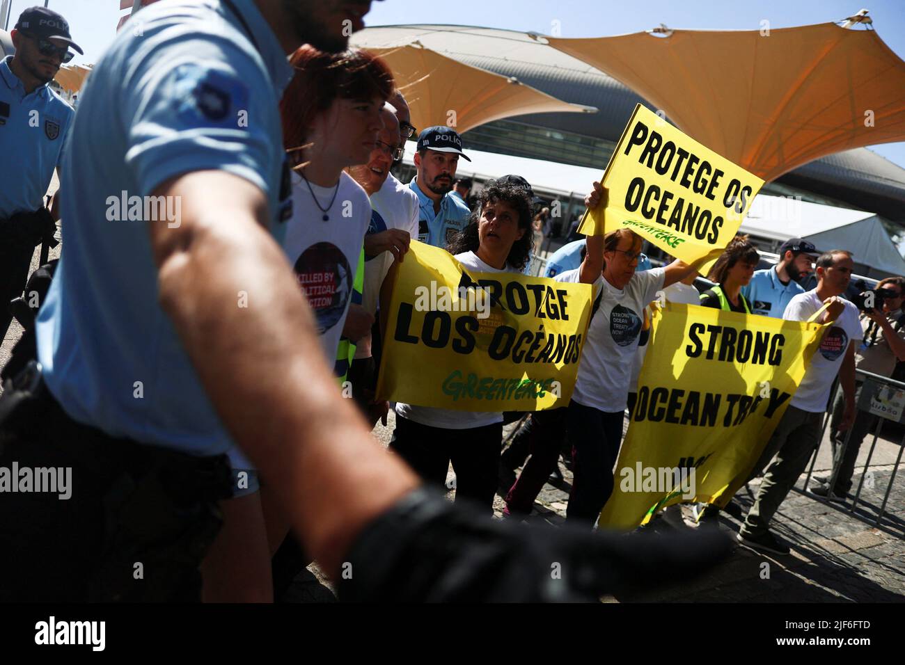 Greenpeace-Aktivisten werden von der Polizei gedrängt, während sie Transparente halten, auf denen stand: „Protect the Oceans“ während einer Demonstration vor der UN-Ozeankonferenz in Lissabon, Portugal, am 30. Juni 2022. REUTERS/Pedro Nunes Stockfoto