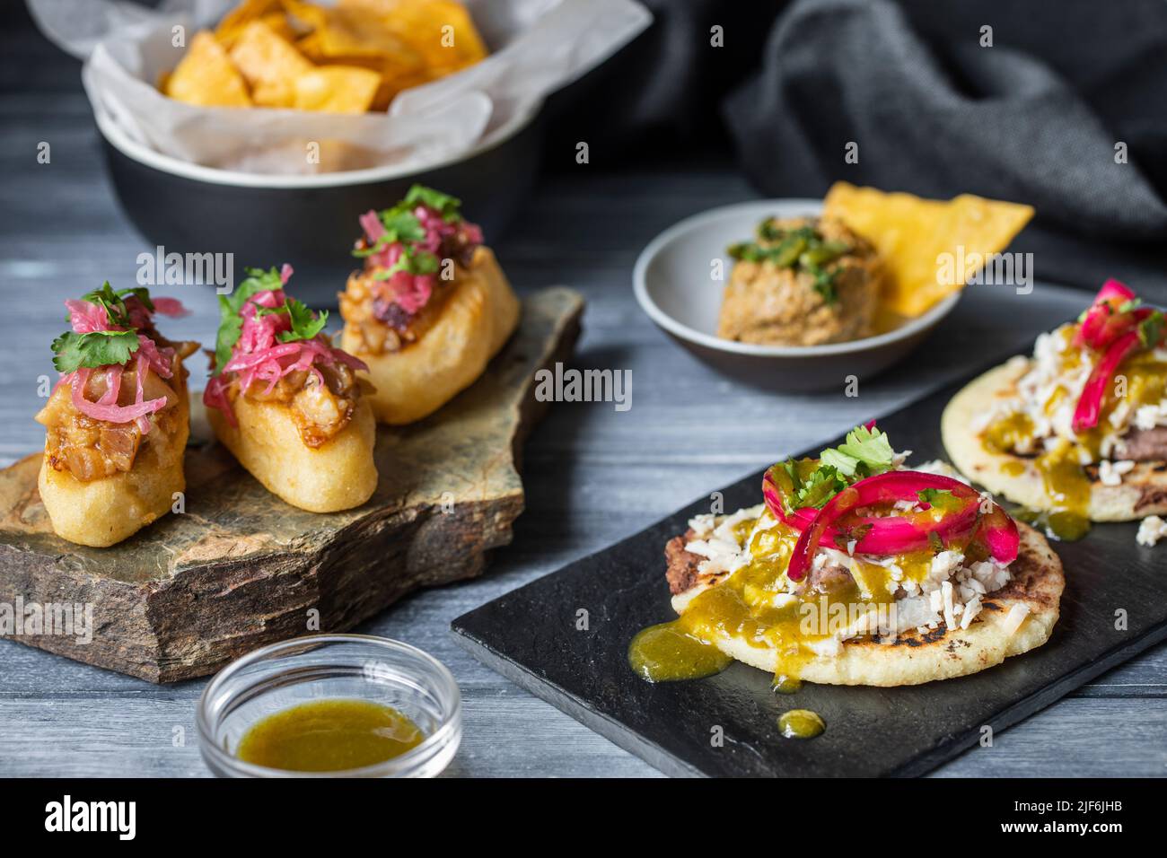 Nahaufnahme köstliche Maya-Polkane Gericht mit Kürbiskernen und weißen Bohnen Toksel in der Nähe von Yucatan Panuchos mit Huhn und Bohnen auf Holztisch Stockfoto
