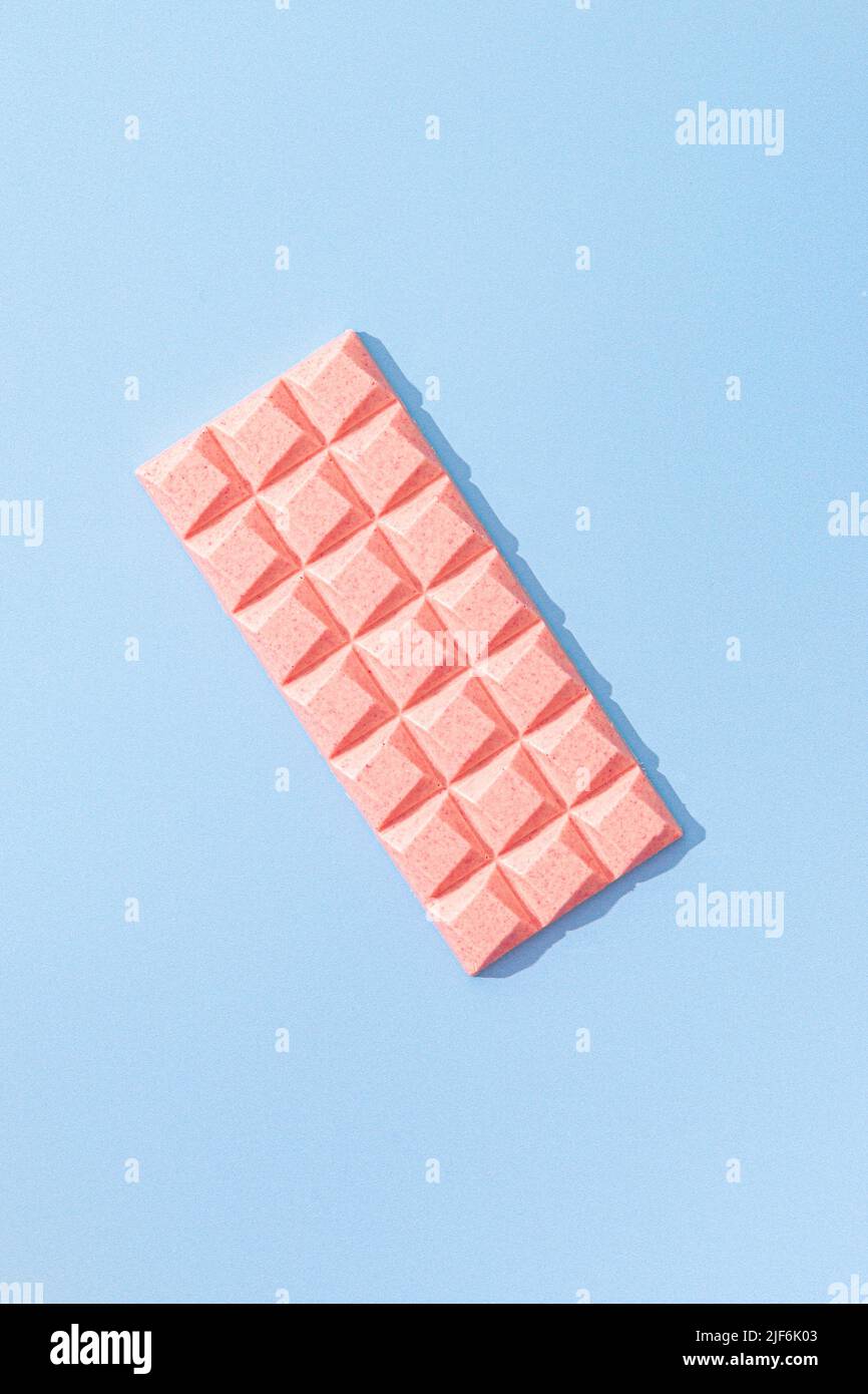 Von oben süßes rosa Schokoriegel auf blauem Hintergrund Stockfoto