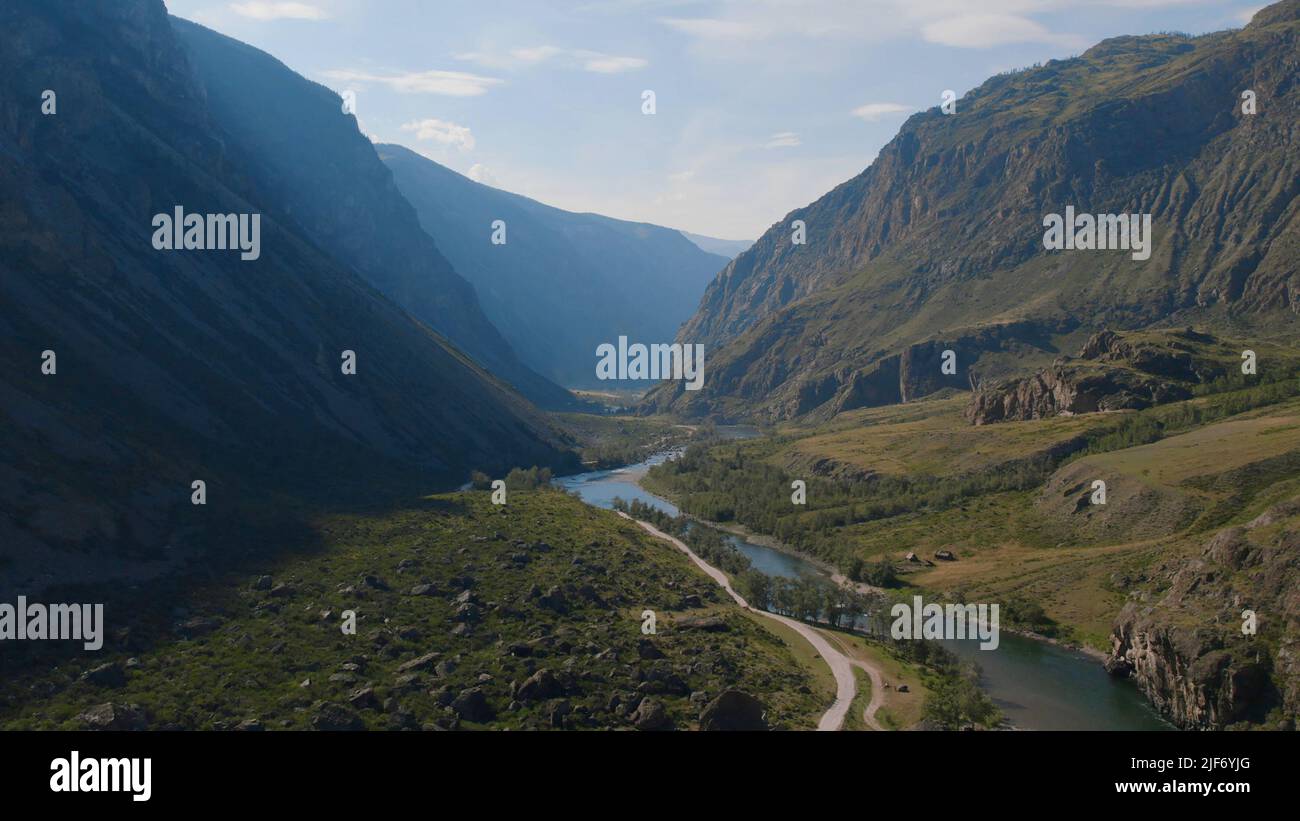 Fluss Chulyshman zwischen grünem Feld und Bergen mit blauem klaren Himmel in Altai, Sibirien, Russland. Schöne Sommer Naturlandschaft bei tagsüber. Stockfoto