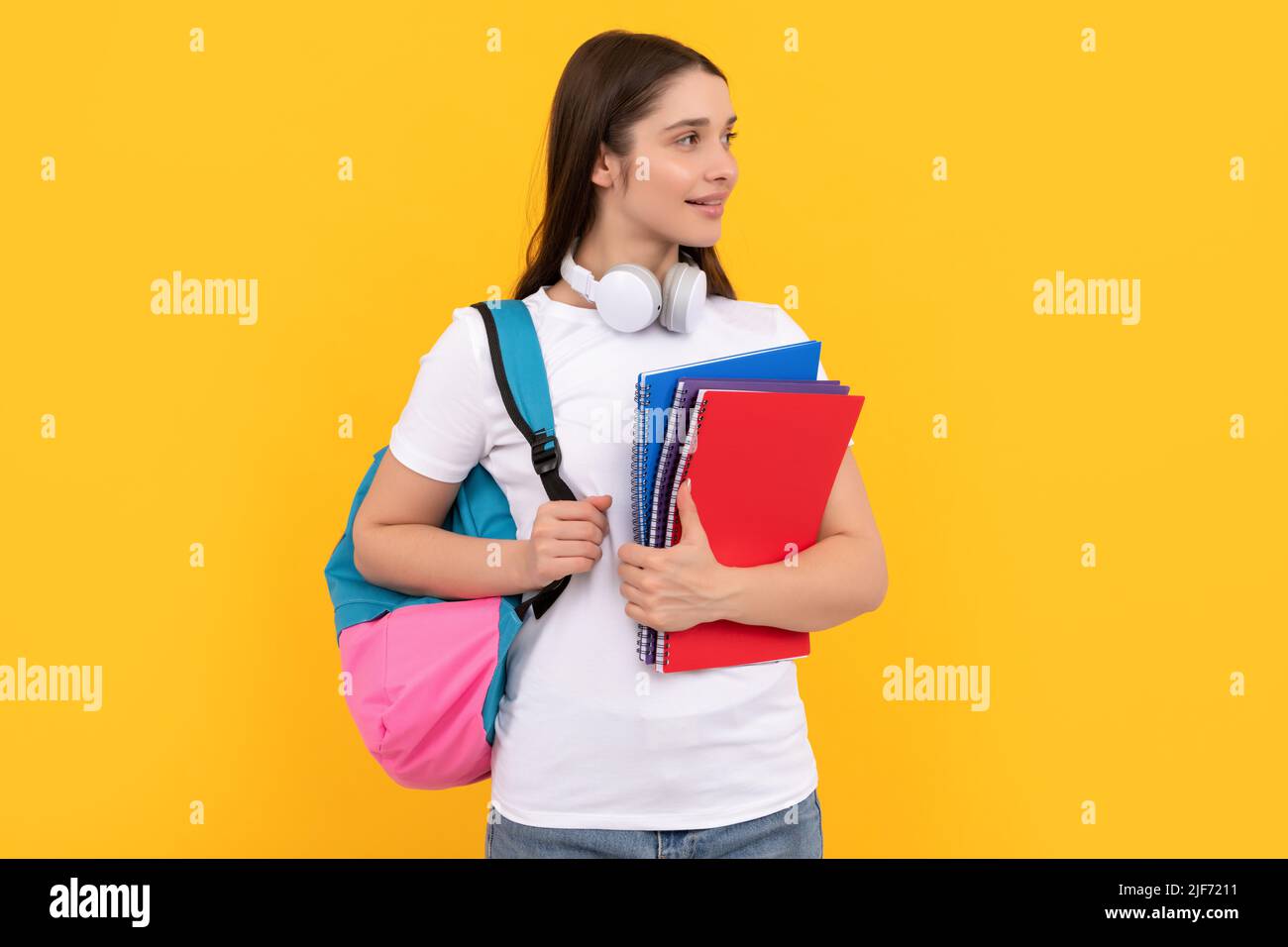 Positive Schüler halten Notebook. Mädchen hält Notebook auf gelbem Hintergrund. Private Lehrerin Stockfoto