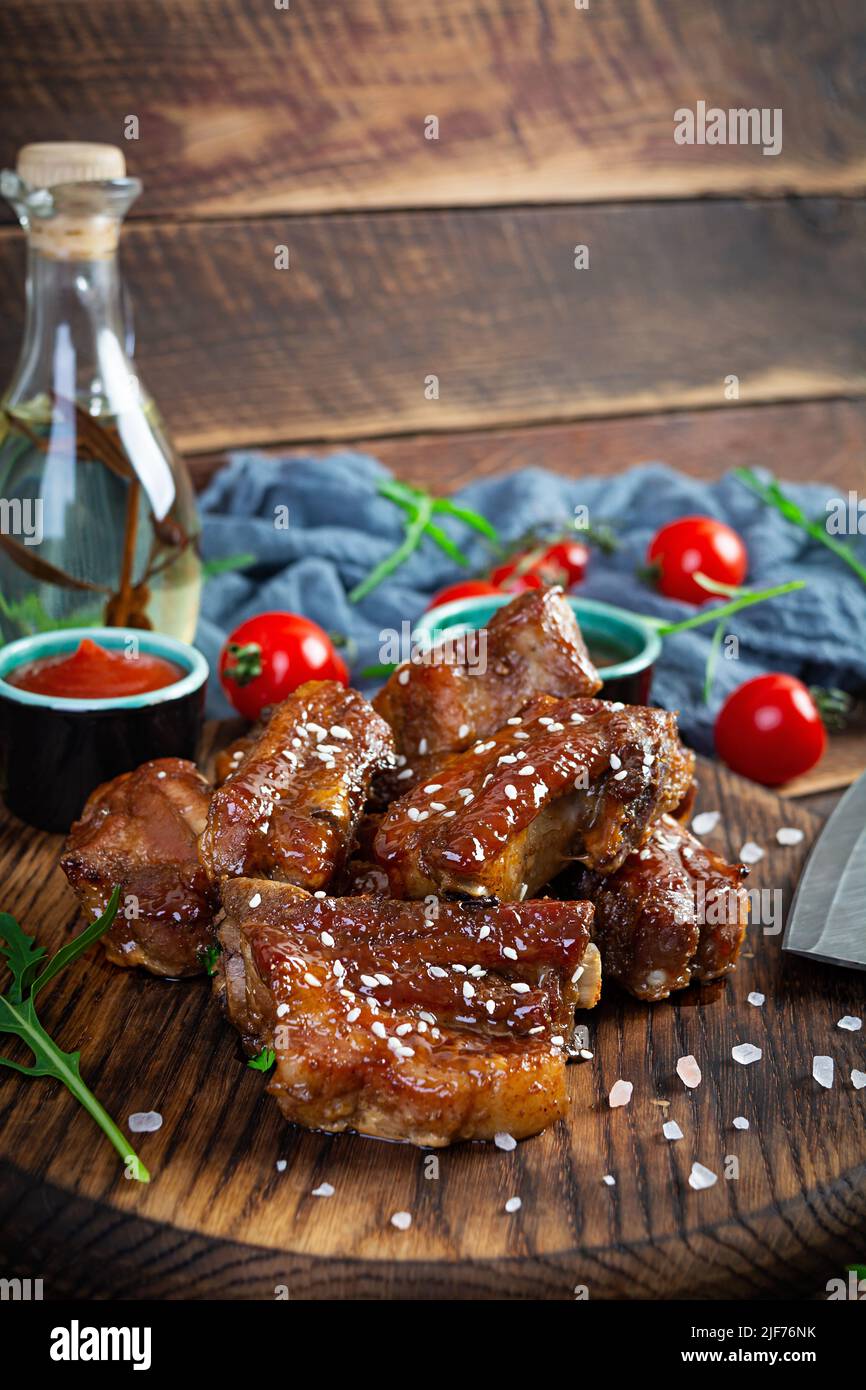 Gegrillte Rippchen in süß-saurer Sauce. Rippchen in Honigsauce mit Kräutern mariniert Stockfoto