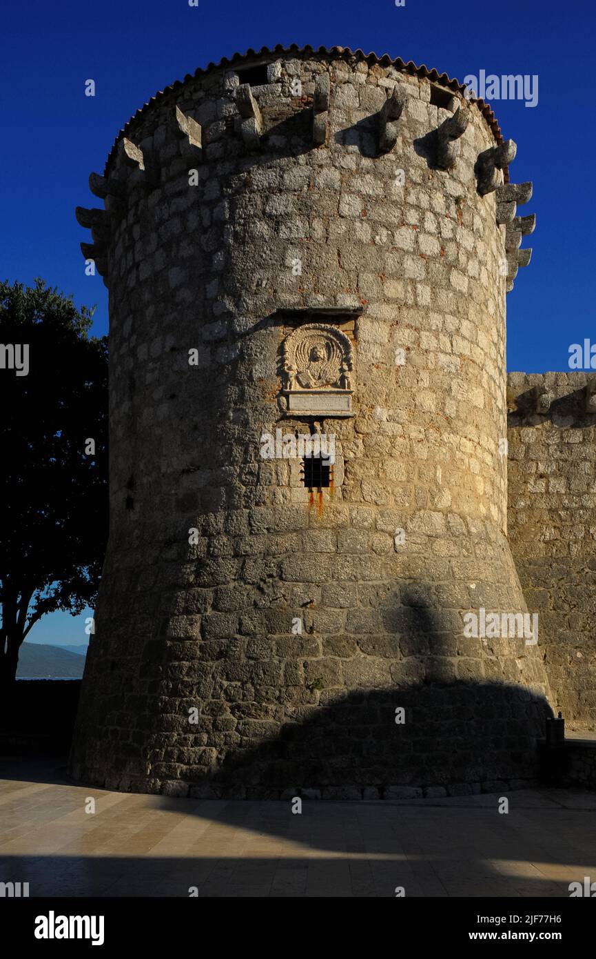 Venezianischer Turm an einer Ecke der mittelalterlichen Burg in Krk, Insel Krk, Kroatien. Die Burg wurde von der kroatischen Frankopanerfamilie oder der französischen Familie erbaut und der Turm stammt wahrscheinlich aus den 1200s Jahren. Als Venedig den Turm 1500 umbaute, wurde jedoch eine Tafel mit dem Emblem von Venedig, dem geflügelten Löwen des Heiligen Markus, in das Steinwerk eingesetzt. Die lateinische Inschrift unter dem Emblem „Aureae Venetorum Libertati“ bedeutet übersetzt „die Goldenen Freiheiten von Venedig“. Stockfoto