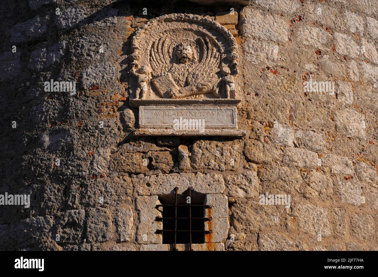 Tafel mit dem Emblem von Venedig, dem geflügelten Löwen des Heiligen Markus, auf einem runden Turm an einer Ecke der mittelalterlichen Burg in Krk, Insel Krk, Kroatien. Die Burg wurde von der kroatischen Frankopanerfamilie oder der französischen Familie erbaut und der Turm stammt wahrscheinlich aus den 1200s Jahren. Diese Tafel wurde jedoch in das Steinwerk eingesetzt, als Venedig den Turm 1500 umbaute. Die lateinische Inschrift unter dem Emblem „Aureae Venetorum Libertati“ bedeutet übersetzt „die Goldenen Freiheiten von Venedig“. Stockfoto