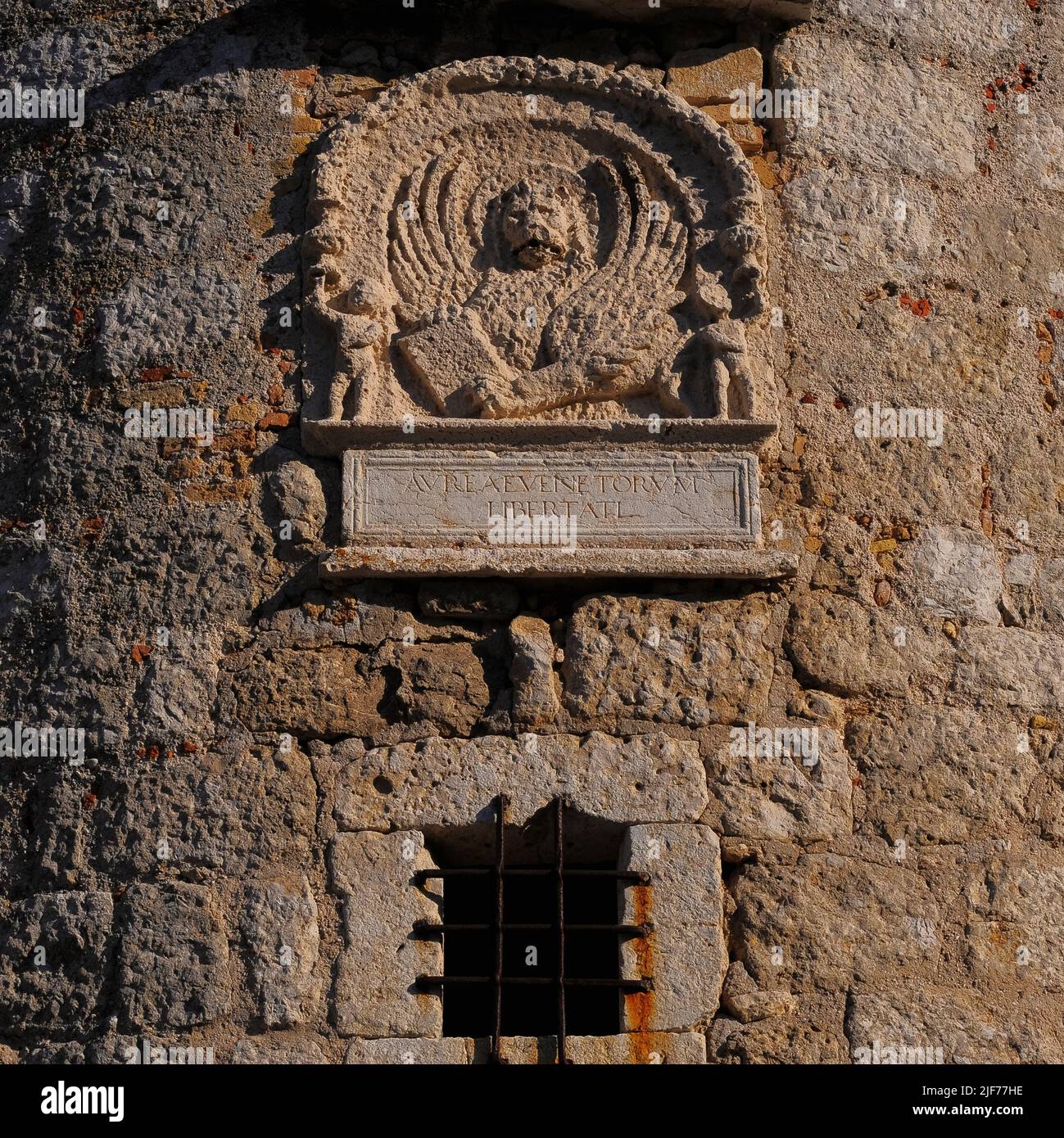 Tafel mit dem Emblem von Venedig, dem geflügelten Löwen des Heiligen Markus, auf einem runden Turm an einer Ecke der mittelalterlichen Burg in Krk, Insel Krk, Kroatien. Die Burg wurde von der kroatischen Frankopanerfamilie oder der französischen Familie erbaut und der Turm stammt wahrscheinlich aus den 1200s Jahren. Diese Tafel wurde jedoch in das Steinwerk eingesetzt, als Venedig den Turm 1500 umbaute. Die lateinische Inschrift unter dem Emblem „Aureae Venetorum Libertati“ bedeutet übersetzt „die Goldenen Freiheiten von Venedig“. Stockfoto