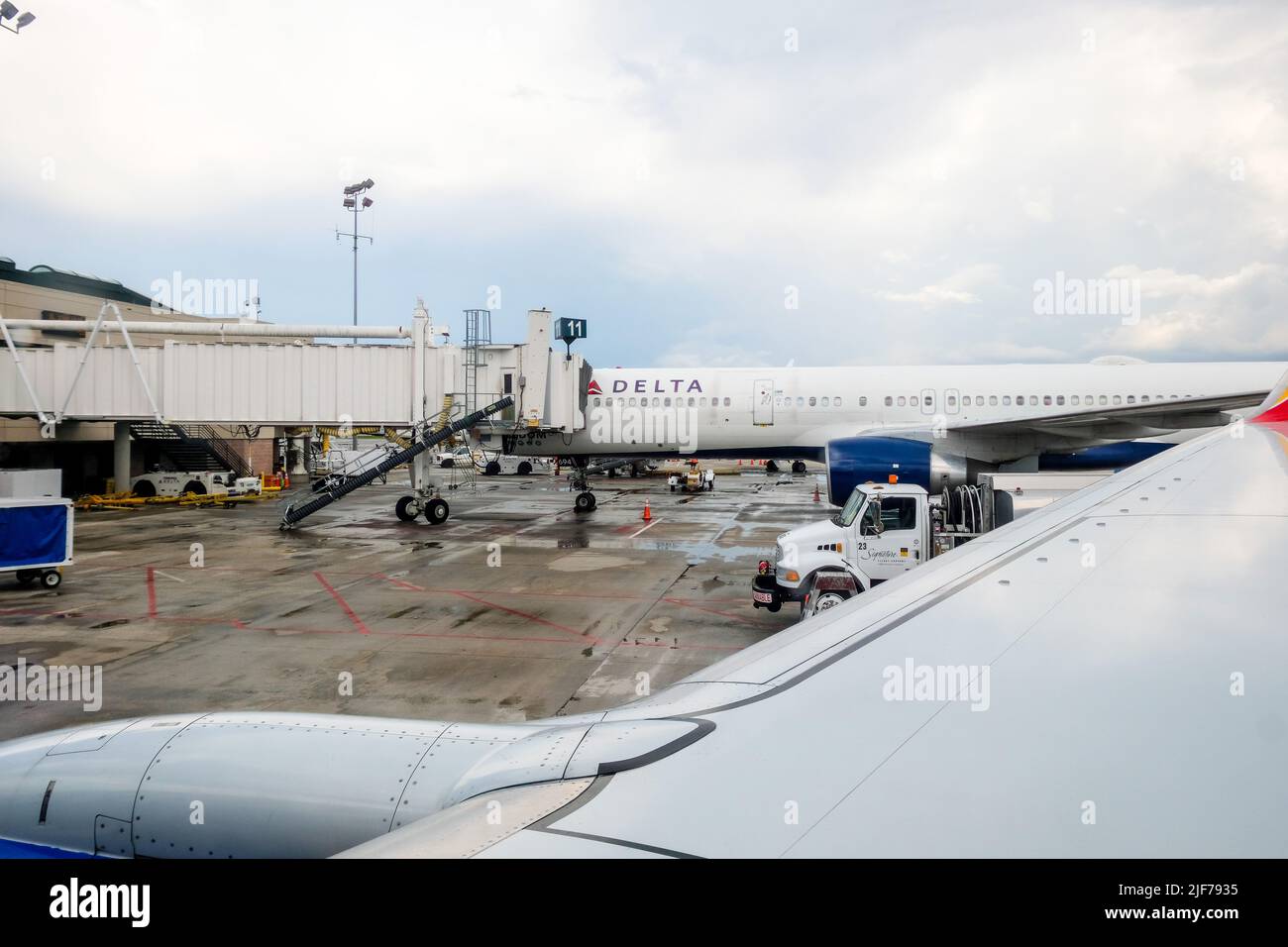 Flugausfälle belasten müde Reisende. Bilder von aktuellen Flugverspätungen in den USA. Gestörte Reisepläne. Flugzeug am jetway. Stockfoto